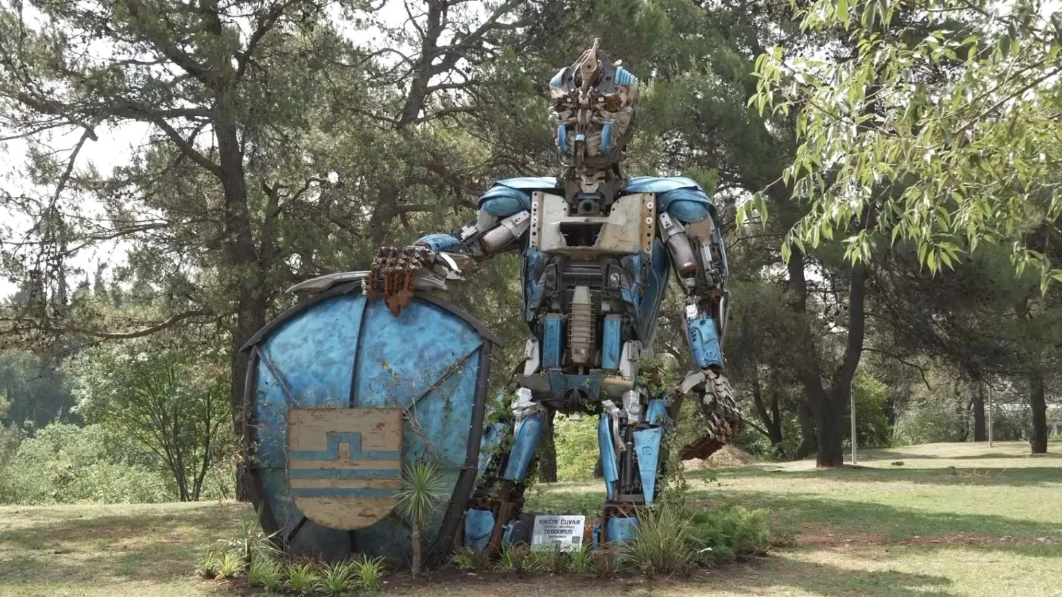 Plavo-siva skulptura transformersa Teodorusa sa štitom i grbom Podgorice, autora Danila Baletića